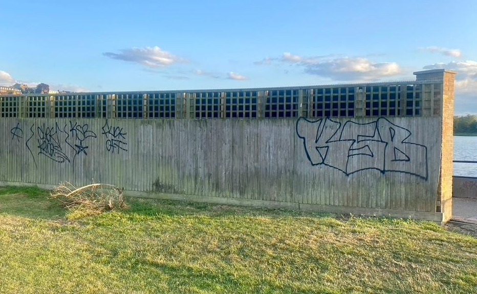 Graffiti spray-painted on the fence by Hathaway Court
