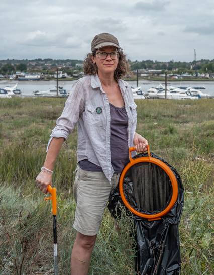 A Friends of the River Medway pilgrim at work with a litter picker and collecting bag hoop