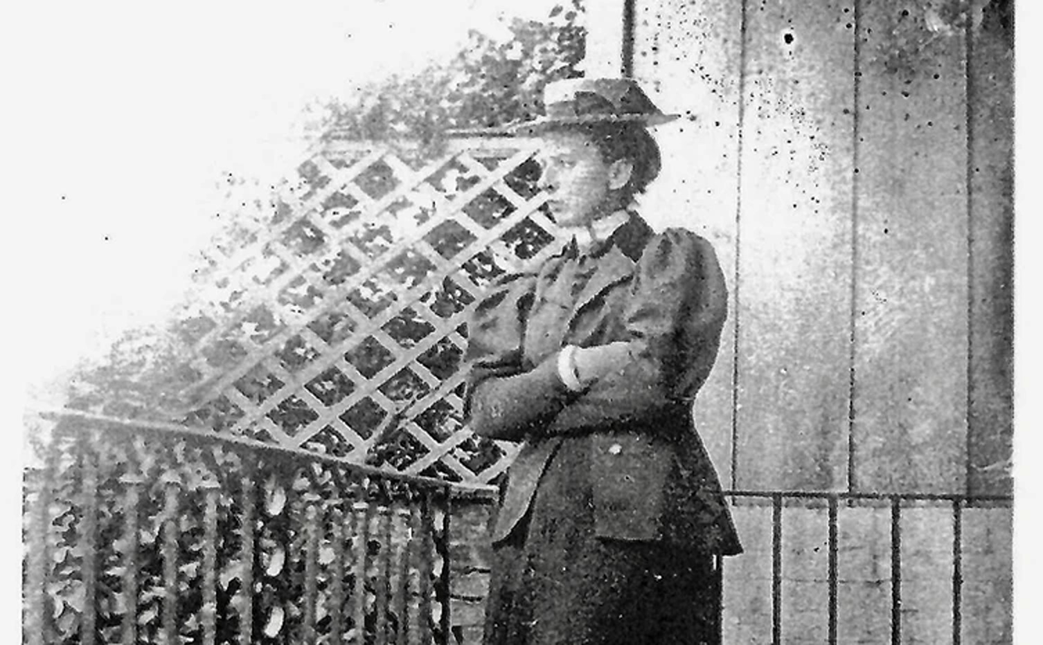 An old monochrome photograph of Vera Conway Gordon standing by a trellis
