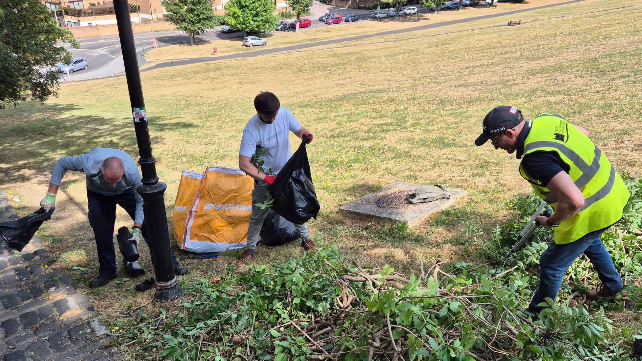 Three volunteers working hard to clear plant overgrowth from the Churchfields Bank steps