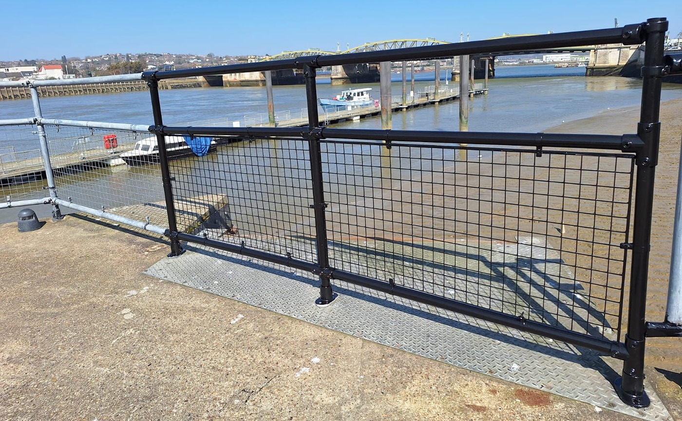 Railings at the end of Rochester Pier, with one section in gleaming fresh black paint